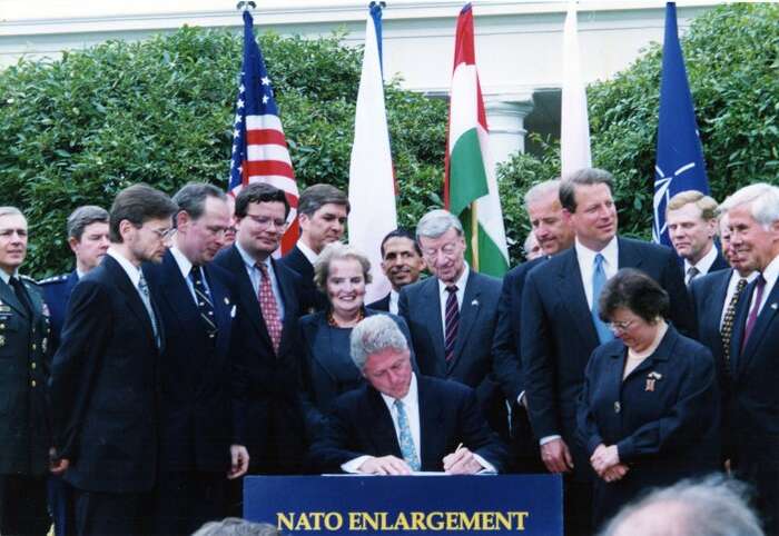 Bill Clinton podepisuje NATO Enlargement Pact. Zástupci Polska, Maďarska a České republiky přihlížejí. Foto archiv Pac1944.org
