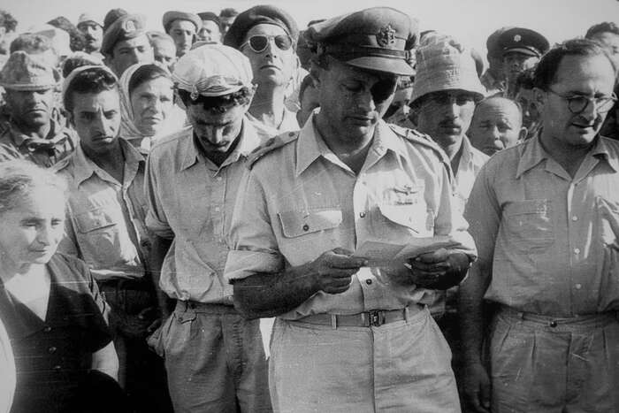 Moše Dajan čte smuteční řeč za Roie Rotberga, kibuc Nachal Oz, duben 1956. Foto Twitter ProvMagazine