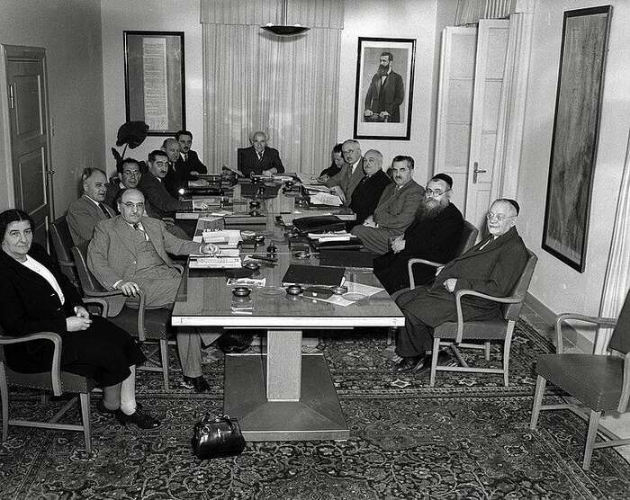 Moše Šaret usazený po levici prvního izraelského ministerského předsedy Davida Ben Guriona na fotografii zachycující první izraelský vládní kabinet v roce 1949. Foto WmC