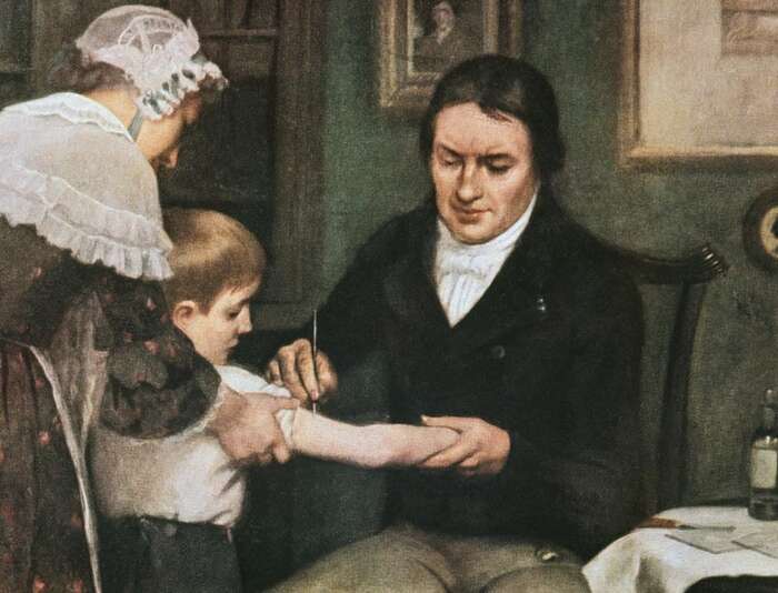 Edward Jenner očkuje osmiletého Jamese Phippse, olej na plátně Ernesta Boarda. Táž scéna je mimochodem vyobrazena pokaždé jinak. Existují i umělecká pojetí, v nichž chlapec vypadá vyděšeně a kolem postávají lidé se zachmuřenými výrazy. Repro DR