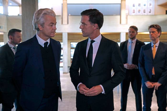 Nizozemský premiér Mark Rutte (uprostřed) v rozhovoru s vůdcem nejsilnější opoziční strany — pravicově populistické PVV — Geertem Wildersem. Foto Yves Herman, AFP