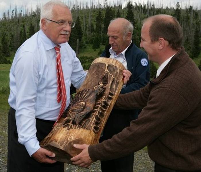 Rok 2011: Náměstek ředitele NP&nbsp;Šumava předává řezbu tetřeva hlušce prezidentu Václavu Klausovi. V&nbsp;pozadí tehdejší ředitel Jan Stráský a&nbsp;kůrovcová gradace někde na&nbsp;Modravsku. Archiv DR